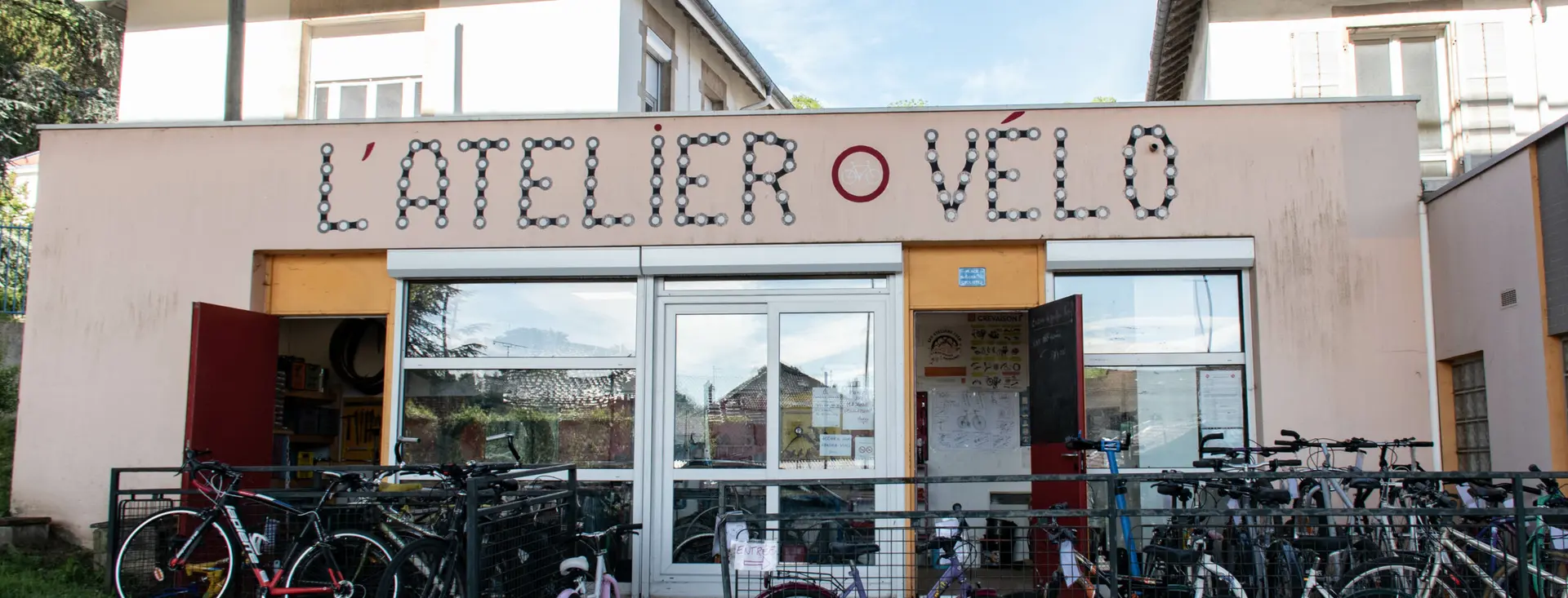 La façade de l’Atelier Vélo de Maxéville, enseigne peinte au-dessus des vitrines.